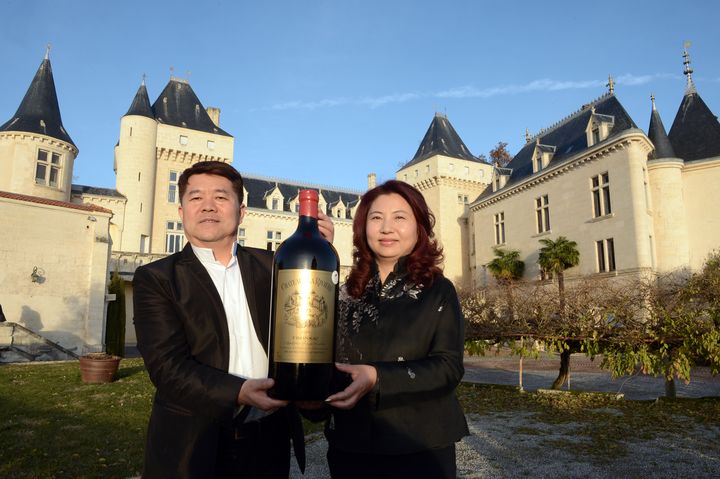 Le millionnaire chinois Lam Kok et son &eacute;pouse posent devant le Chateau de La Rivi&egrave;re qu'ils viennent d'acqu&eacute;rir, le 19 d&eacute;cembre 2013, en Gironde.&nbsp; (MEHDI FEDOUACH / AFP)