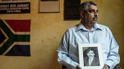 Imtiaz Cajee, neveu d'Ahmed Timol, avec une photo de son oncle, mort en octobre 1971 pendant le régime de l'apartheid. C'est en grande partie grâce à lui que l'enquête concernant ce décès suspect a pu être relancée. Photo prise le 25 mai 2017 à Prétoria. (AFP - GIANLUIGI GUERCIA)