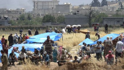 Des Syriens r&eacute;fugi&eacute;s &agrave; Suruc (Turquie), en route vers&nbsp;Koban&eacute;&nbsp;apr&egrave;s la fuite des combattants de l'Etat islamique, le 17 juin 2015. (BULENT KILIC / AFP)