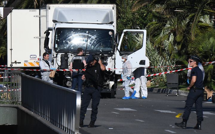 Des policiers inspectent le camion utilisé lors de l'attaque à Nice (Alpes-Maritimes), le 15 juillet 2016. (ANNE-CHRISTINE POUJOULAT / AFP)