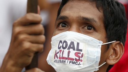 "Le charbon tue !", a inscrit ce manifestant de Manille sur son masque anti-pollution. (ERIK DE CASTRO / REUTERS)