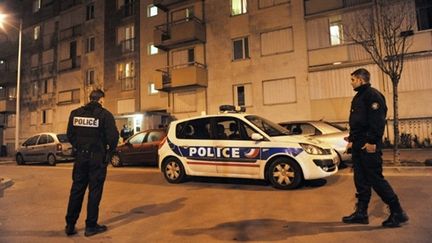 Des policiers montent la garde devant l'immeuble où deux personnes ont péri poignardées, à Nanterre (9/2/2011) (AFP / Etienne Laurent)