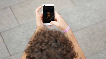 Un jeune homme joue à l'application "Pokémon Go" à Madrid (Espagne), le 28 juillet 2016. (SERGIO PEREZ / REUTERS)