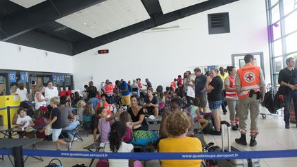 Des familles évacuées de Saint-Martin attendent à l'aéroport de Pointe-à-Pitre, en Guadeloupe, le 9 septembre 2017. (HELENE VALENZUELA / AFP)