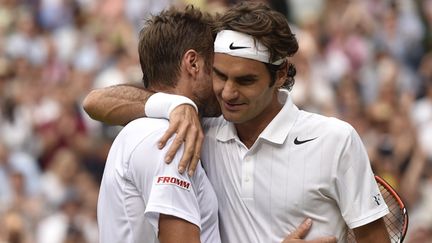 Roger Federer étreint son compatriote Stan Wawrinka sur le Centre court de Wimbledon (TOBY MELVILLE / POOL)