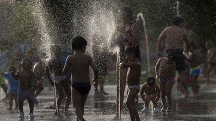 Des enfants jouent dans des fontaines à Madrid, le 3 août 2018. (PIERRE-PHILIPPE MARCOU / AFP)