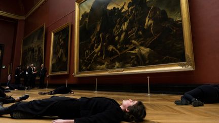 Des militants se sont allongés devant "Le Radeau de la Méduse" de Géricault au Louvre pour protester contre le partenariat du musée avec Total
 (Thomas Samson / AFP)