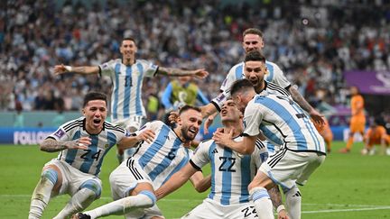 La délivrance pour Lautaro Martinez. L'attaquant argentin vient de transformer le tir au but de la victoire en quarts de finale face aux Pays-Bas (2-2, 4-3 t.a.b), le 9 décembre 2022, et se fait ensevelir par ses coéquipiers. (ALBERTO PIZZOLI / AFP)