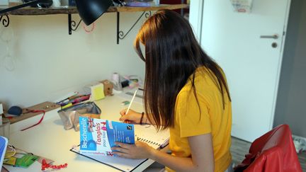 Une étudiante assise à son bureau pour réviser ses examens, (photo d'illustration), le 04 juin 2021. (VANESSA MEYER / MAXPPP)