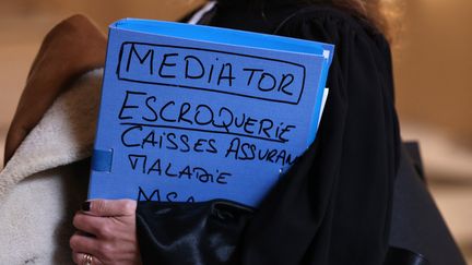 Une avocate tenant un dossier à l'ouverture du procès en appel du groupe Servier devant la Cour d'appel de Paris, le 9 janvier 2023. (THOMAS SAMSON / AFP)