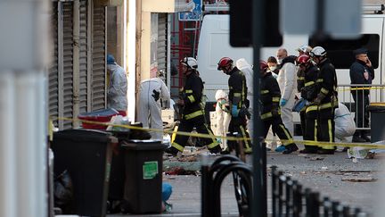 Les experts de la police et les pompiers travaillent à l'extérieur d'un immeuble de Saint-Denis (Seine-Saint-Denis), le 18 novembre 2015, après un assaut mené par les forces de l'ordre. (JOEL SAGET / AFP)