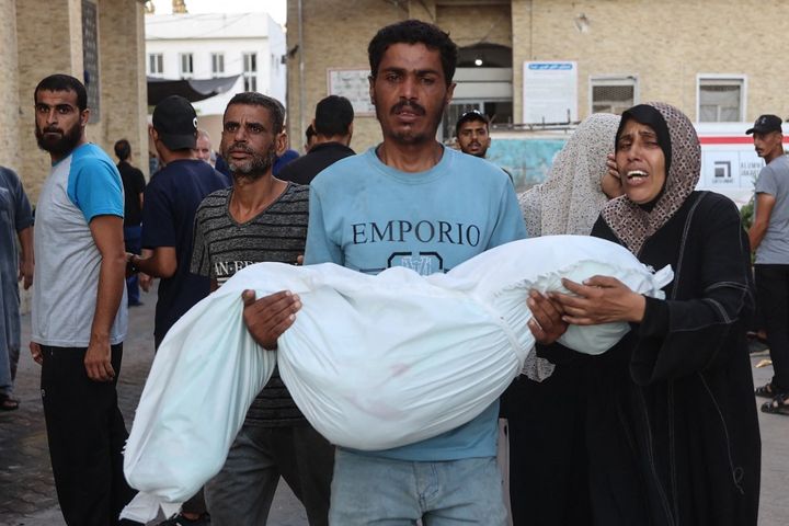 A family leaves al-Maamadani hospital in Gaza City on August 10, 2024, with the body of a relative who died in a school attack on the night of August 9-10. (OMAR AL-QATTAA / AFP)