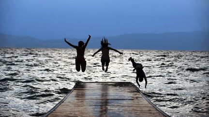 Des jeunes filles plongent dans le lac d'Ohrid (Mac&eacute;doine), o&ugrave; les temp&eacute;ratures d&eacute;passent les 40&deg;C, le 12 juillet 2012. (ROBERT ATANASOVSKI / AFP)