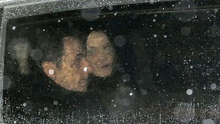 Le pr&eacute;sident candidat Nicolas Sarkozy (G) et son &eacute;pouse Carla en chemin pour retrouver leurs supporters &agrave; La Mutualit&eacute; &agrave; Paris, le 22 avril 2012. (JEAN-PAUL PELISSIER / REUTERS)