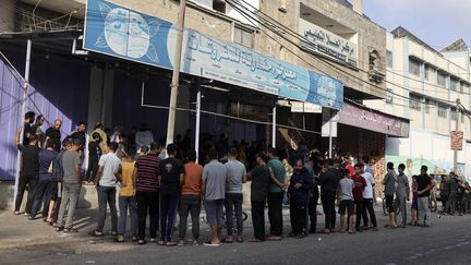 Des Palestiniens font la queue devant une boulangerie de Rafah pour se procurer du pain, le 22 octobre 2023. (MOHAMMED ABED / AFP)