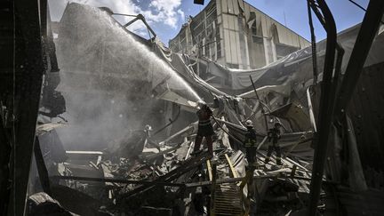 Des pompiers éteignent un incendie dans une usine dans la ville de Bakhmut, dans la région du Donbass, dans l'est de l'Ukraine, le 27 mai 2022. (ARIS MESSINIS / AFP)