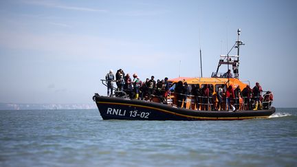 Des migrants sur un bateau de secours de la Royal National Lifeboat Institution dans la Manche, le 16 août 2023. (HENRY NICHOLLS / AFP)