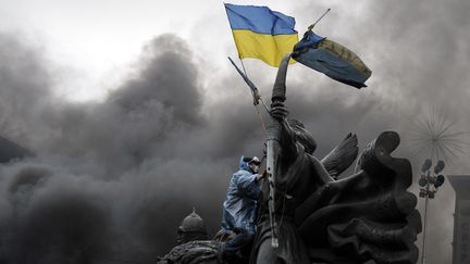 Un manifestant &agrave; Kiev brandit un drapeau ukrainien, le 20 f&eacute;vrier 2014. (LOUISA GOULIAMAKI / AFP)