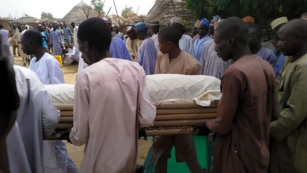 Un groupe d'hommes enterre une victime de l'attaque de Boko Haram dans le village de Lawanti (nord-est du Nigeria) le 20 février 2019. (AUDU ALI MARTE / AFP)