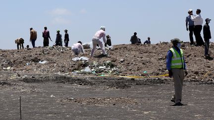 Des Ethiopiens ramassent les débris du vol d'Ethiopian Airlines, le 15 mars 2019 à Addis-Abeba (Ethiopie). (MINASSE WONDIMU HAILU / ANADOLU AGENCY / AFP)