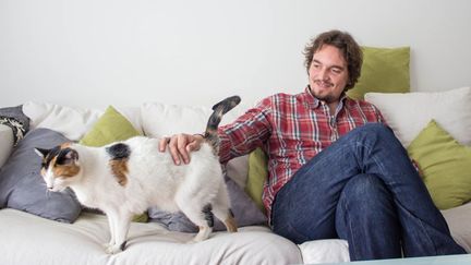 Militant écologiste devenu défenseur du véganisme, Olivier pose avec l'un de ses chats à son domicile d'Asnières (Hauts-de-Seine), le 18 mars 2014. (MATHIEU DEHLINGER / FRANCETV INFO)