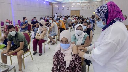 Une femme tunisienne reçoit une dose du vaccin chinois Sinopharm au Palais des Congrès à Tunis, le 20 juillet 2021. (FETHI BELAID / AFP)