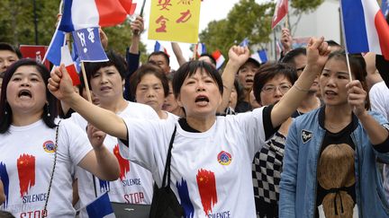 Des manifestants d'origine chinoise défilent à Paris, le 21 août 2016,&nbsp;pour réclamer la fin&nbsp;des violences répétées à leur encontre après la mort d'un couturier chinois agressé à Aubervilliers. (BERTRAND GUAY / AFP)