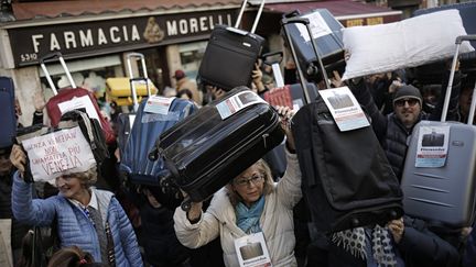 Pour exprimer leur mécontement, 300 d'entre eux ont manifesté en plein cœur de la Cité des Doges, samedi 12 novembre, avec une valise à la main. (MARCO BERTORELLO / AFP)