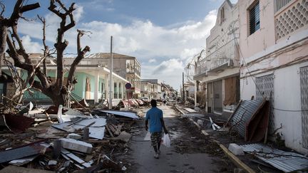 Un homme marche dans les rues de l'île de Saint-Martin dévastée par le passage de l'ouragan Irma, le 8 septembre 2017. (MARTIN BUREAU / AFP)