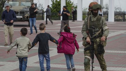 Un soldat russe sur une place centrale de Melitopol, au sud de l'Ukraine. (SERGEI ILNITSKY / EPA)