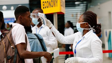 Prise de température d'un passager à l'aéroport international d'Accra. Le Ghana fait partie des pays africains qui ont fermé leurs frontières aux étrangers venant des pays les plus touchés. (FRANCIS KOKOROKO / X03672)