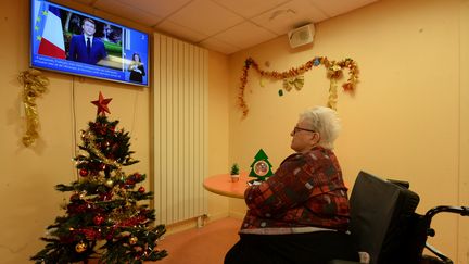 La résidente d'un Ehpad de Chartres regarde les voeux d'Emmanuel Macron, le 31 décembre 2021. (JEAN-FRANCOIS MONIER / AFP)