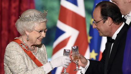 Elizabeth II trinque avec Fran&ccedil;ois Hollande &agrave; l'Elys&eacute;e, &agrave; l'occasion du d&icirc;ner d'Etat en son honneur, le 6 juin 2014. (ERIC FEFERBERG / POOL / AFP)