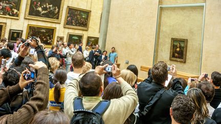 Des visiteurs du Louvre tentent d'obtenir une photographie de "La Joconde" de Léonard de Vinci, le 17 septembre 2016 à Paris. (BERNARD JAUBERT / ONLY FRANCE / AFP)