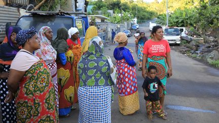 Des femmes qui se tiennent devant els gendarmes, dans le quartier de Majicavo, dans la commune de Koungou, le 25 avril 2023. (CHAFION MADI / AFP)