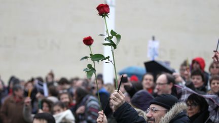 Dans la foule, des manifestants ont brandi des roses, en hommage aux victimes des attentats, et des crayons, la seule arme dont disposaient les dessinateurs de "Charlie Hebdo" face &agrave; leurs assassins. (CHARLY TRIBALLEAU / AFP)