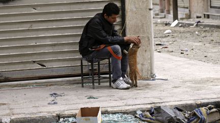 Un membre de l'Arm&eacute;e syrienne libre caresse un chat dans une rue d'Alep (Syrie), le 22 octobre 2012. (REUTERS)