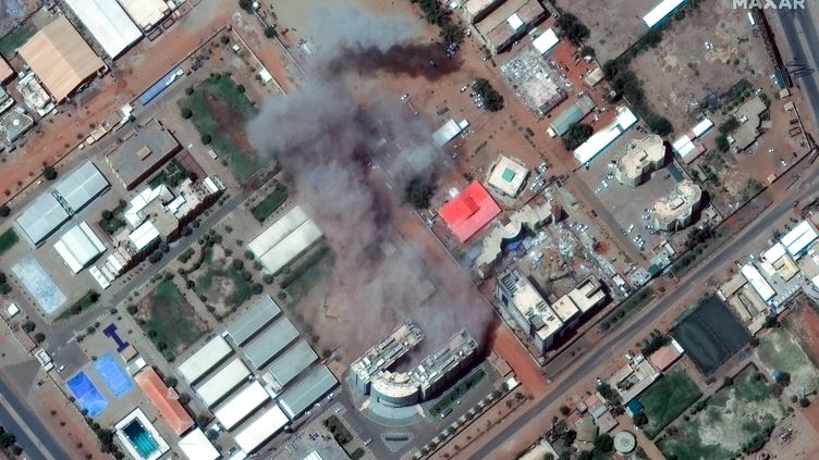 This satellite image taken by Maxar Technologies shows smoke billowing from a building near Khartoum International Airport on April 17, 2023. (SATELLITE IMAGE 2022 MAXAR TECH / AFP)