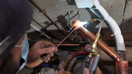 Un plombier en plein travail. Un travailleur indépendant. Photo d'illustration. (FRANCOIS DESTOC / MAXPPP)