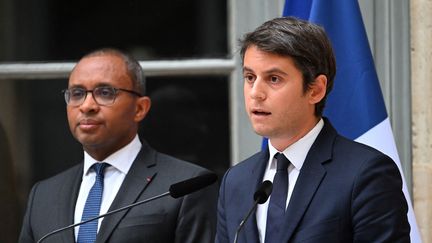 Gabriel Attal, nouveau ministre de l'Education nationale, lors de la passation de pouvoir avec son prédécesseur Pap Ndiaye, le 20 juillet 2023. (EMMANUEL DUNAND / AFP)