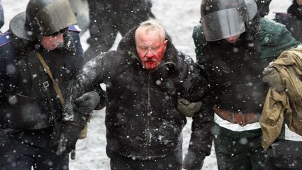 La police anti-&eacute;meute ukrainienne embarque un manifestant bless&eacute;, mercredi 22 janvier 2014 &agrave; Kiev (Ukraine). (ANATOLII BOIKO / AFP)