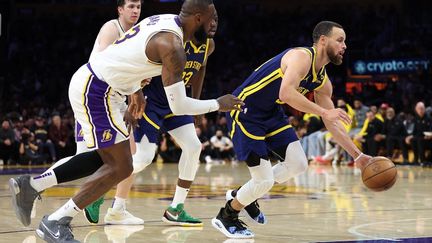 Lebron James (à gauche) et Stephen Curry (à droite), deux des grandes stars de la NBA, lors d'un match entre les Los Angeles Lakers et les Golden State Warriors en 2024. (SEAN M. HAFFEY / GETTY IMAGES NORTH AMERICA via AFP)