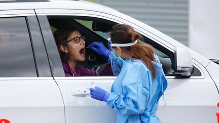 Une patiente testée au volant de sa voiture alors que plusieurs cas positifs de Covid-19 ont conduit à un vérouillage de quatre jours dans la région métropolitaine de Perth en Australie (29 juin 2021). (TREVOR COLLENS / AFP)