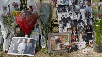 Des photos et des fleurs déposées en hommage à Alain Delon, mort à l'âge de 88 ans, devant sa résidence de Douchy (Loiret), le 19 août 2024. (GUILLAUME SOUVANT / AFP)