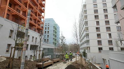 Des ouvriers à l'oeuvre sur le site du village olympique de Paris 2024, le 19 décembre 2023, douze jours avant la livraison du site. (THOMAS SAMSON / AFP)