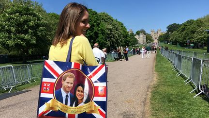 Une habitante de Windsor portant un sac imprimé avec la photo du futur couple princier Harry et Meghan Markle, sur le chemin du Long Walk au château de Windsor, le 17 mai 2018. (TERESA DAPP / DPA)