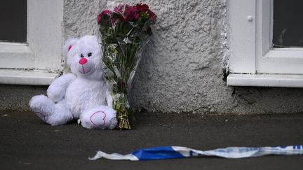 Une peluche et un bouquet de fleurs ont été déposés au sol, le 23 mai 2017, près du lieu de l'attentat perpétré à Manchester, la veille.&nbsp; (OLI SCARFF / AFP)