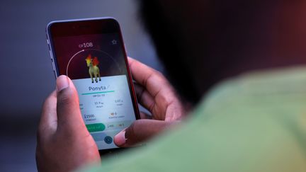 Un Américain joue à "Pokémon Go" à Times Square, à New York (Etats-Unis), le 11 juillet 2016. (MARK KAUZLARICH / REUTERS)