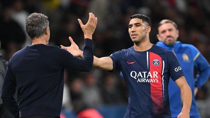 Achraf Hakimi et Luis Enrique lors de la large victoire du PSG contre l'OM (4-0), le 24 septembre 2023 au Parc des Princes. (BERTRAND GUAY / AFP)