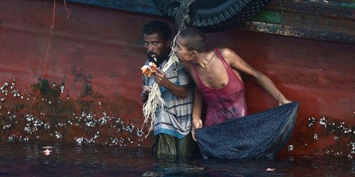 Des réfugiés rohingyas en train de manger de la la nourriture larguée par un hélicoptère de l'armée thaïlandaise à côté d'un bateau mouillant près de l'île de Koh Lipe (sud de la Thaïlande) le 14 mai 2015. (AFP FP PHOTO / FILES / CHRISTOPHE ARCHAMBAULT)